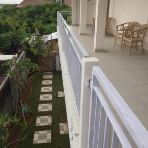 a white fence on a balcony with a garden at Laksmi Guest House in Canggu