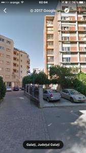 a city street with cars parked in a parking lot at Faleza Apartment in Galaţi