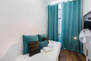 a room with a white couch and a blue wall at Faro Cosy Guesthouse in Faro