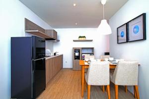 a kitchen and dining room with a table and a refrigerator at Ariama Serviced Residence in Jakarta