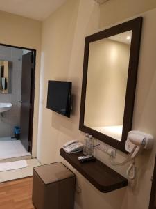 a bathroom with a mirror and a phone on a counter at Seasons View Hotel in Kuantan
