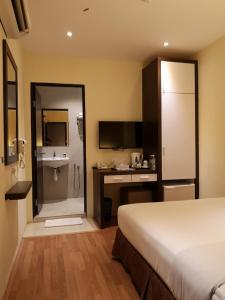 a bedroom with a bed and a bathroom with a sink at Seasons View Hotel in Kuantan