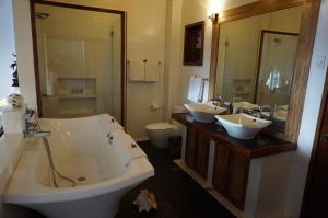 a bathroom with two sinks and a bath tub at Vellago Resort in El Nido
