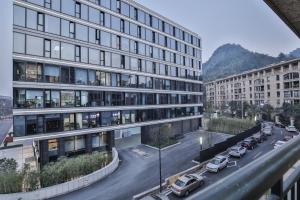 a view of a building with cars parked in a parking lot at SSAW Boutique Hotel Hangzhou Ant Z-space in Hangzhou