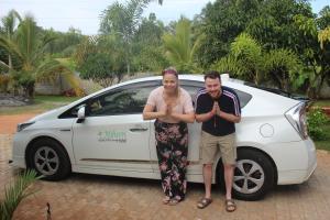 a man and a woman standing next to a white car at Miheen Hotel & Resort - Anuradhapura in Mihintale