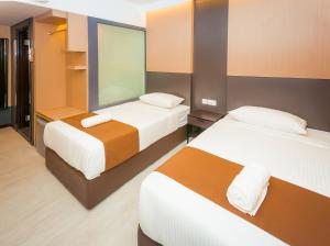 a hotel room with two beds and a window at Icon Hotel Segamat in Segamat