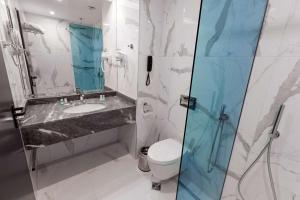 a bathroom with a sink and a toilet and a mirror at Best Western PLUS Premium Inn in Sunny Beach