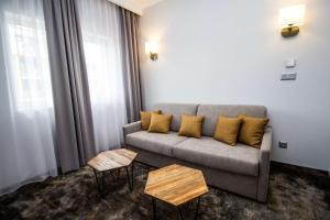 a living room with a couch and two tables at Best Western PLUS Premium Inn in Sunny Beach