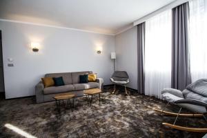 a living room with a couch and two chairs at Best Western PLUS Premium Inn in Sunny Beach