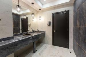 a bathroom with two sinks and two mirrors at Best Western PLUS Premium Inn in Sunny Beach