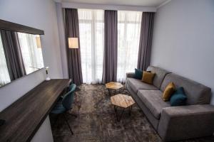 a living room with a couch and a table at Best Western PLUS Premium Inn in Sunny Beach