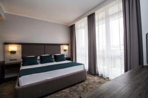 a bedroom with a large bed with blue pillows at Best Western PLUS Premium Inn in Sunny Beach