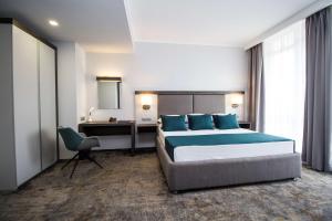 a bedroom with a bed and a desk and a chair at Best Western PLUS Premium Inn in Sunny Beach