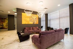 a living room with two couches and a painting at Best Western PLUS Premium Inn in Sunny Beach