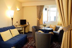 a living room with a blue couch and a table at Les Reflets Jaunes in Givet