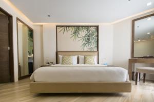 a bedroom with a large bed with a large painting on the wall at Boracay Haven Suites in Boracay