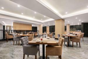 a restaurant with tables and chairs in a room at Ramada by Wyndham Sakarya Hendek in Hendek