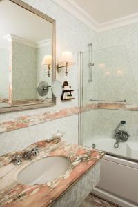 a bathroom with a sink and a tub and a mirror at Hotel Imperiale by OMNIA hotels in Rome