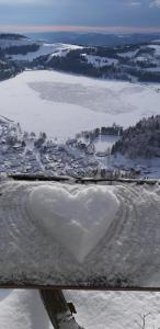 ein herzförmiges Herz im Schnee neben einem Fluss in der Unterkunft Rekreačný domček Judka in Dedinky