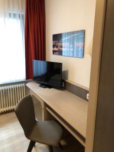 En tv och/eller ett underhållningssystem på Gästehaus Hotel Wilms