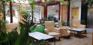 eine Terrasse mit Stühlen und einem Tisch in einem Gebäude in der Unterkunft Benny's City Hotel in Sihanoukville