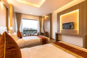 una camera d'albergo con due letti e una tv di Landmark Kathmandu a Kathmandu