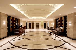 a lobby with a man sitting at a desk in a building at Aswar Hotel Suites in Al Khobar