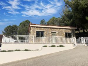 a stone house with a white fence at Iliovasilema in Platy