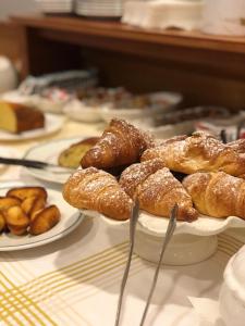 une table recouverte de assiettes de pâtisseries et d'autres aliments dans l'établissement Hotel Delfina, à Signa
