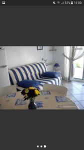 Una sala de estar con un sofá y una mesa con flores. en 5 Cours du Maréchal Juin, en Châtelaillon-Plage