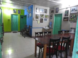 a dining room with green and blue doors and a table at Vamoose Latpanchor Homestay in Mangpu