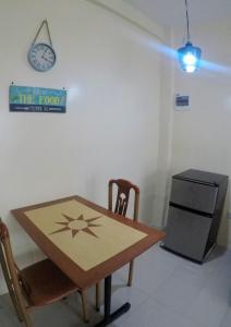 a table and chair in a room with a clock at R & D Island Lodge in Bantayan Island +31 photos