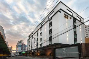 a white building on the side of a street at Browndot Hotel Masan Odong in Changwon