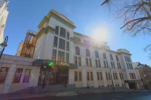 a large white building with the sun behind it at Hotel Hayal in Kazan