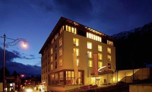 a large building with many windows at night at Hotel Allegra in Pontresina