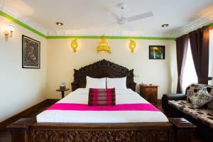 una camera con un grande letto e un divano di Okay Palace Hotel a Phnom Penh