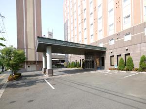 a parking lot in front of a large building at Hotel Route-Inn Tosu Ekimae in Tosu