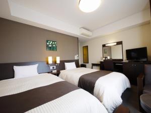Llit o llits en una habitació de Hotel Route-Inn Tosu Ekimae