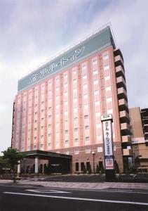 un gran edificio con escritura en un lado en Hotel Route-Inn Tosu Ekimae, en Tosu