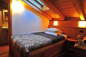 1 dormitorio con 1 cama en una habitación de madera en Alpi & Golf Hotel, en Bormio