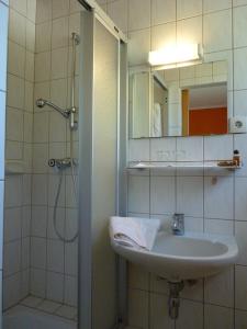 łazienka z umywalką i prysznicem z lustrem w obiekcie Pension Brönimann w mieście Ossiach