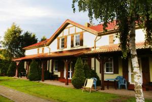 uma grande casa branca com um telhado vermelho em Barwy Morza - domki em Rowy