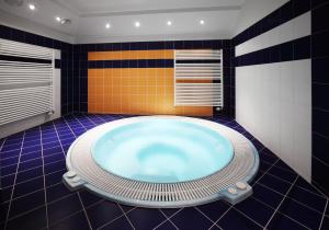 ein Bad mit einer großen Badewanne in der Mitte in der Unterkunft Wellness Hotel IRIS in Pavlov