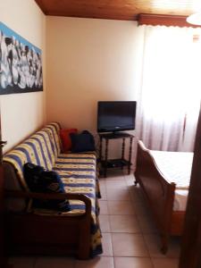 a living room with a couch and a flat screen tv at Villa Karanti in Limenas