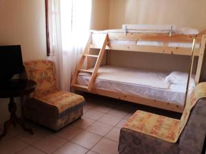 Cette chambre comprend 2 lits superposés et une chaise. dans l'établissement Villa Karanti, à Thasos