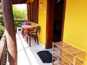 una casa amarilla con una mesa y sillas en un porche en Villa Karanti, en Limenas