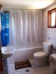 een badkamer met een toilet, een bad en een wastafel bij Villa Karanti in Limenas