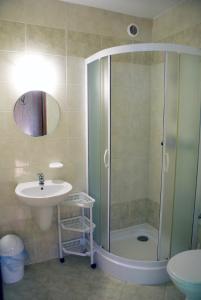 ein Bad mit einer Dusche und einem Waschbecken in der Unterkunft Barwy Morza - domki in Rowy