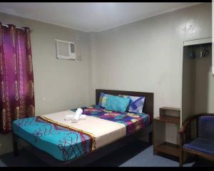 um pequeno quarto com uma cama e uma cadeira em Madid's Inn Beach Resort em Boracay