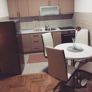 cocina con mesa, sillas y fregadero en Annabel’s Home, en Sarajevo